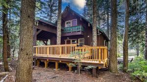 a large wooden house in the middle of trees at Moosewood Cabin - Meredith Lodging in Government Camp