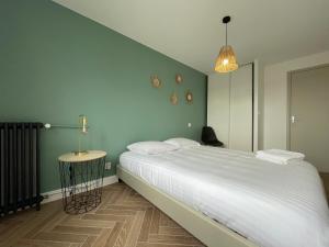 Un dormitorio con una gran cama blanca y una lámpara en Appartement cosy avec vue imprenable sur la cité, en Carcassonne