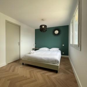1 dormitorio con cama y pared verde en Appartement cosy avec vue imprenable sur la cité, en Carcassonne