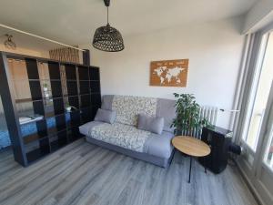 een woonkamer met een bank en een tafel bij Belle vue à 500m des thermes - climatisé in Royat