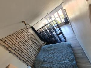 een slaapkamer met een blauw bed en een trap bij Belle vue à 500m des thermes - climatisé in Royat