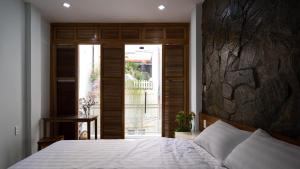 a bedroom with a bed and a large window at Homestay TITO in Ho Chi Minh City