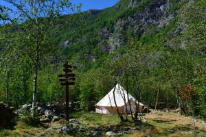 a tent in the woods with a mountain in the background at Hardanger Basecamp in Osa