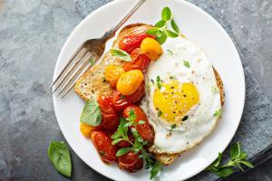 a breakfast plate with an egg and tomatoes on toast at HOTEL RUPAKOT AND ROOFTOP RESTAURANT in Bhaktapur
