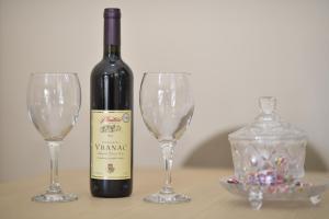 a bottle of wine and two wine glasses on a table at Promenade,5 min Old Town in Kotor