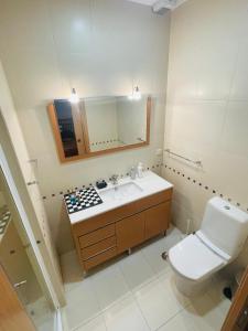 a bathroom with a toilet and a sink and a mirror at Conforto em Fátima in Fátima