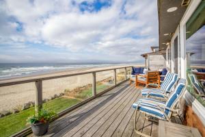 balkon z krzesłami i widokiem na plażę w obiekcie Pelican's Flight w mieście Rockaway Beach