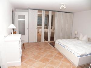 1 dormitorio con cama blanca y espejo en Haus Nordseeresidenz Wohnung 71, en Westerland