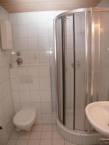 ein Bad mit einer Dusche, einem WC und einem Waschbecken in der Unterkunft Haus Nordseeresidenz Wohnung 63 in Westerland