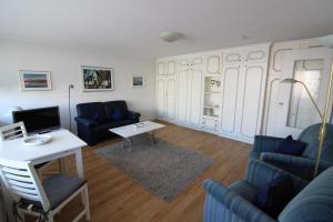 ein Wohnzimmer mit einem Sofa und einem Tisch in der Unterkunft Haus Nordseeresidenz Wohnung 63 in Westerland