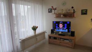 een woonkamer met een flatscreen-tv op een tafel bij Haus Norderhoog Wohnung 47 in Westerland