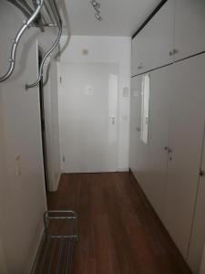 een lege kamer met witte muren en een gang met een stoel bij Haus Norderhoog Wohnung 55 in Westerland