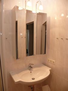 een badkamer met een witte wastafel en een spiegel bij Haus Norderhoog Wohnung 55 in Westerland