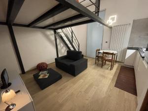 uma sala de estar com uma cadeira preta e uma mesa em Apartment Typex em Milão