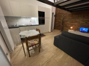 a kitchen and a living room with a table and a couch at Apartment Typex in Milan