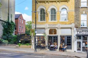 a group of people sitting outside of a building at Oak & Poppy in London