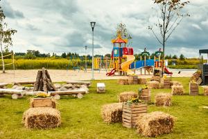 un parc avec une aire de jeux avec des bottes de foin dans l'établissement Suntago Village - Oficjalny nocleg Suntago, à Mszczonów