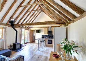 a kitchen and living room with exposed beams at Barley Byre in Rolvenden