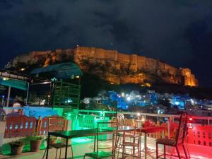 a table and chairs in front of a city at night at Golden Dreams Guest House in Jodhpur