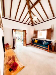 a living room with a couch and a table at Bangalô de Charme na Praia do Patacho - Rota Ecológica dos Milagres in Pôrto de Pedras
