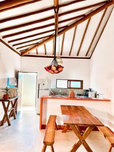 a kitchen with a wooden table and a counter at Bangalô de Charme na Praia do Patacho - Rota Ecológica dos Milagres in Pôrto de Pedras