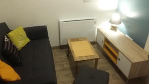 - un petit salon avec un canapé et une table dans l'établissement Appartement cosy 25 m², à Limoges