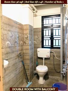 a bathroom with a toilet and a sink at Gracious Lodge in Shillong