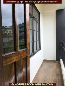 una habitación vacía con puerta y ventanas en Gracious Lodge, en Shillong