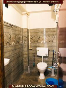 y baño con aseo y lavamanos. en Gracious Lodge, en Shillong