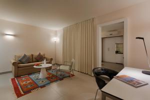 a living room with a couch and a table and chairs at Desert Iris Hotel in Yeroẖam