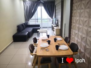 a dining room with a table and a couch at H2H - Comfort Cottage @ Majestic Ipoh in Ipoh