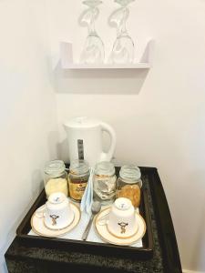 a tray with plates and jars and a tea pot at Double Room Charlotte in London
