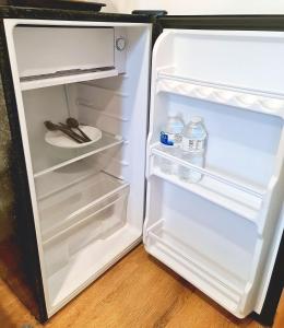 an open refrigerator with bottles of water in it at Double Room Charlotte in London