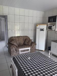 a living room with a couch and a refrigerator at Apartamentos C. Santos in Penha