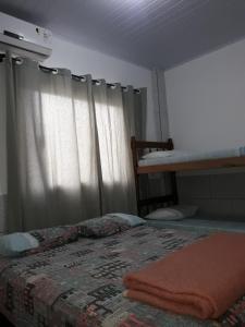 Un dormitorio con una cama con una manta. en Apartamentos C. Santos, en Penha