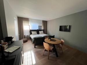 een kleine kamer met een bed en een tafel en een bed bij Beneden - Langs in Diepenheim