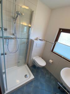 une salle de bain avec une douche, des toilettes et un lavabo dans l'établissement Hus Waterkant, à Friedrichskoog