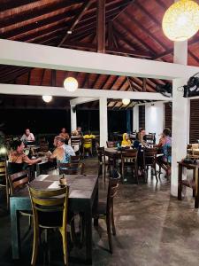 un groupe de personnes assises à table dans un restaurant dans l'établissement Moonstone Villas, à Tangalle