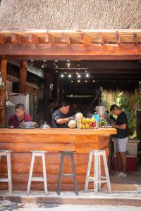 un grupo de hombres parados en un bar en Tunich Jungle Cabañas en Tulum