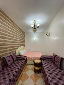 ein Wohnzimmer mit einem Sofa und einem Bett in der Unterkunft Dar Bennis médina in Rabat