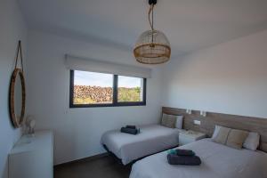 a bedroom with two beds and a window at North Shore Villas, Villa MAKAI, Heated & Shared Pool in Lajares