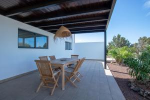 North Shore Villas, Villa MAKAI, Heated & Shared Pool في لاجاريس: طاولة وكراسي خشبية على الفناء