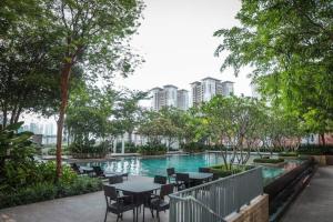 a swimming pool with tables and chairs in a city at Tree Premier Suite Strait Quay Luxury Marina Suite in Tanjong Tokong