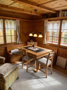 comedor con mesa de madera y sillas en Bambi Lodge Ferienwohnung auf knapp 1400 m nahe Arosa, en Peist