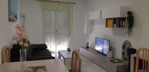 a living room with a couch and a tv at Apartamento Junto a El Corte Inglés Algeciras 3 in Algeciras