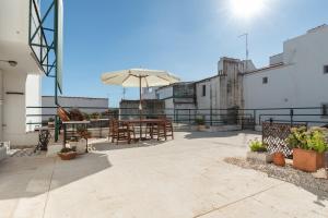 eine Terrasse mit einem Tisch und einem Sonnenschirm in der Unterkunft Casa da Avó Bia in Estremoz