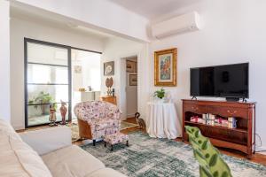uma sala de estar com um sofá e uma televisão em Casa da Avó Bia em Estremoz