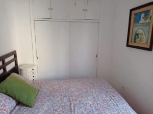 1 dormitorio con 1 cama y armarios blancos en Clean and comfortable budget flat, en Fuengirola