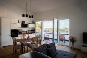 een woonkamer met een tafel en stoelen en een keuken bij Panorama Suite 20 in Sinsheim