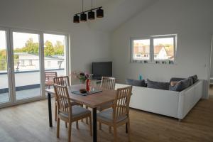 een woonkamer met een tafel en stoelen en een bank bij Panorama Suite 20 in Sinsheim